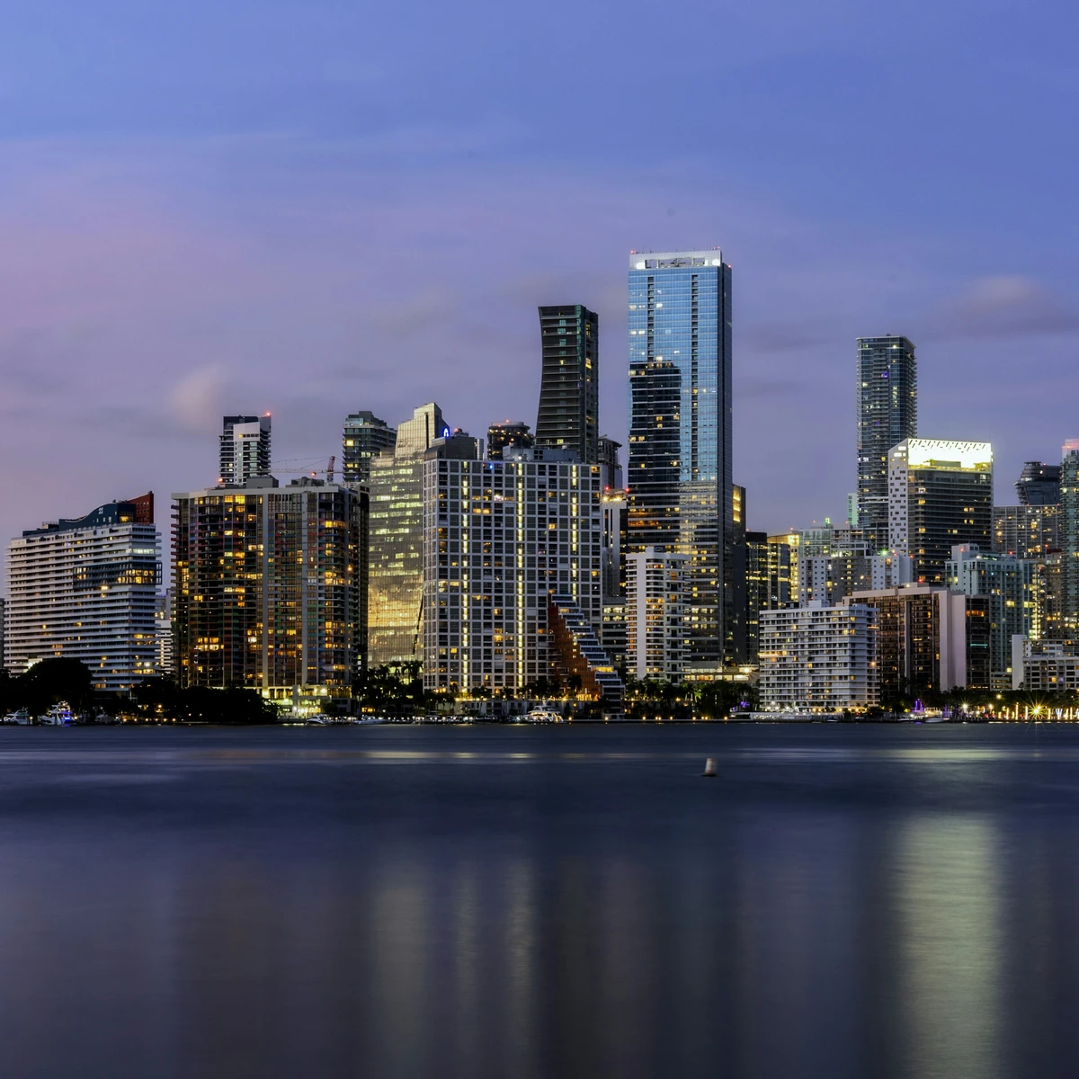 Illuminated Brickell skyline at blue hour, reflected in Biscayne Bay, Miami
