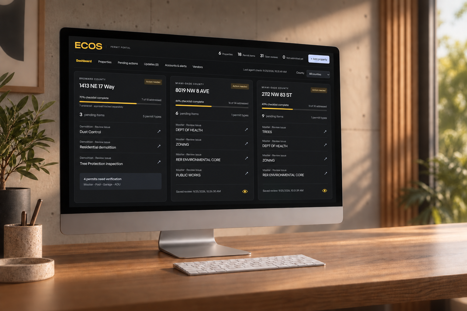 ECOS permit portal dashboard on an iMac in a warm architectural studio